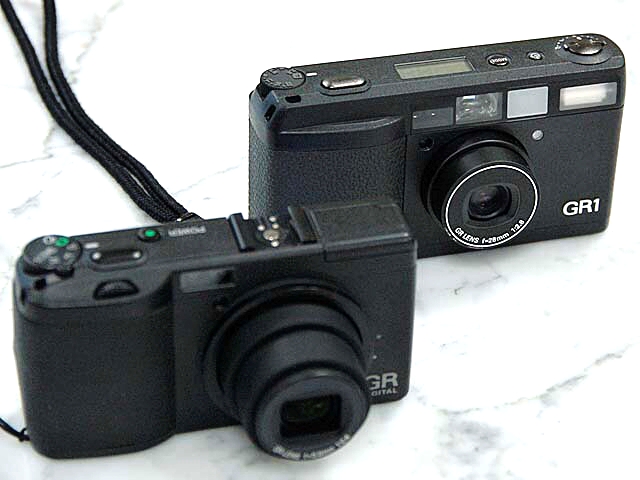<b>シリーズ初のデジタルカメラ「GR DIGITAL」（2005年発売、手前）と「GR1」（1996年発売、奥）</b>