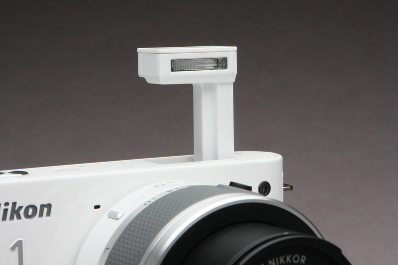 <b>カメラ背面部にあるストロボボタンをスライドさせると、真上にポップアップする内蔵ストロボ。カッコの善し悪しは別にして、その形状はどことなくユニークだ</b>