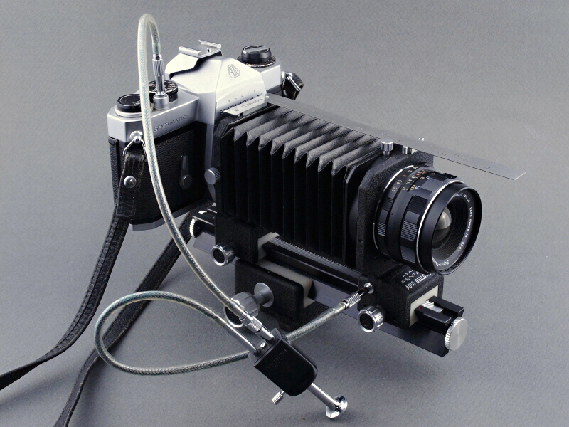 <b>比較として紹介するM42マウントのペンタックス製ベローズ。シャッターボタンに装着したダブルレリーズにより「半自動絞り」が作動する。非常に重厚な作りで三脚の使用が前提になっている。かつてはどのメーカーからも、似たような仕様のベローズが発売されていた</b>