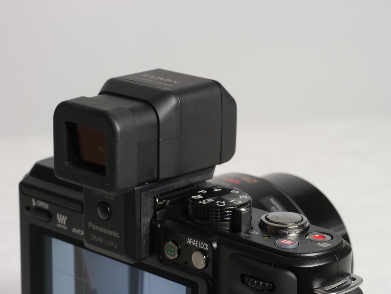 <b>DMW-LVF2を装着したところ。ボディ上部からかなり出っ張ってしまう。上方90度にチルトできるのも便利。接眼部下のボタンは液晶モニターとビューファインダーの切り替え用ボタン</b>