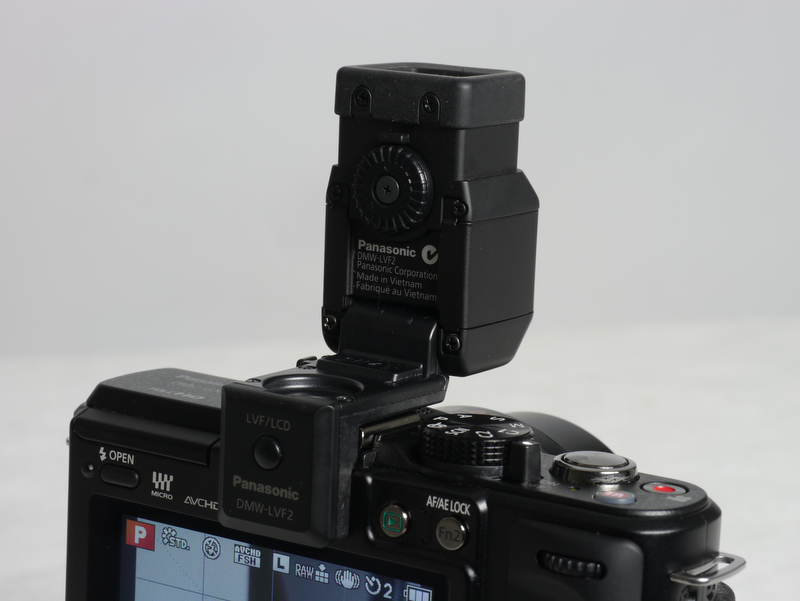 <b>DMW-LVF2を装着したところ。ボディ上部からかなり出っ張ってしまう。上方90度にチルトできるのも便利。接眼部下のボタンは液晶モニターとビューファインダーの切り替え用ボタン</b>