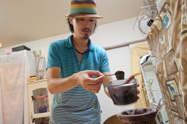 <b>連日の気温が30℃以上の夏日が続いた7月〜8月に取材した。エアコン使っていても、扇風機は必需品だ。モデルさんが布団圧縮袋に入ったらすぐにチャックを閉めて、中の空気を掃除機で吸い出す。この時に活躍する掃除機は三菱製の紙パック方式のパワフルなモノ。最新式のダイソンなどよりも旧式のこのタイプが一番いいらしい。撮った写真はすぐにパソコンで確認して、次のポーズの参考にする。豆から買ってきて自分で焙煎したコーヒーでおもてなし。</b>