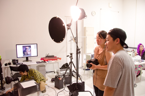 <b>この日は、いま大人気急上昇中の異色のビジュアル系ロックバンド「女王蜂」のCDジャケット他の撮影。身体に特殊メイクを施し、ムラ布バックドロップ&amp;ストロボヘッドにカラーフィルターを使用しての怪しいゴージャス満点のスタジオ撮影だった</b>