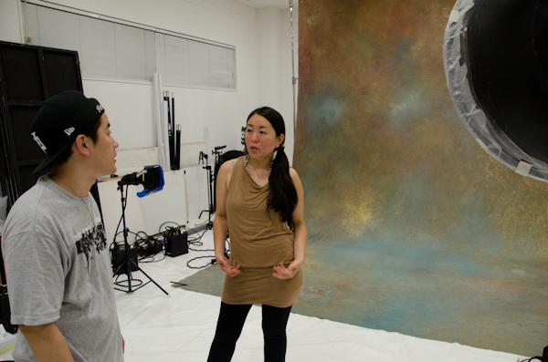 <b>この日は、いま大人気急上昇中の異色のビジュアル系ロックバンド「女王蜂」のCDジャケット他の撮影。身体に特殊メイクを施し、ムラ布バックドロップ&amp;ストロボヘッドにカラーフィルターを使用しての怪しいゴージャス満点のスタジオ撮影だった</b>