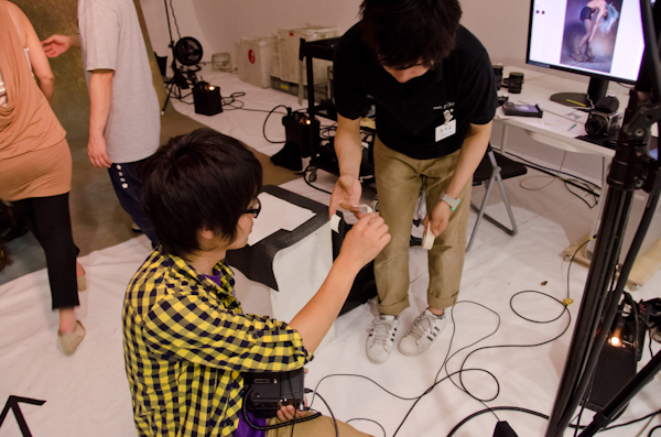 <b>この日は、いま大人気急上昇中の異色のビジュアル系ロックバンド「女王蜂」のCDジャケット他の撮影。身体に特殊メイクを施し、ムラ布バックドロップ&amp;ストロボヘッドにカラーフィルターを使用しての怪しいゴージャス満点のスタジオ撮影だった</b>