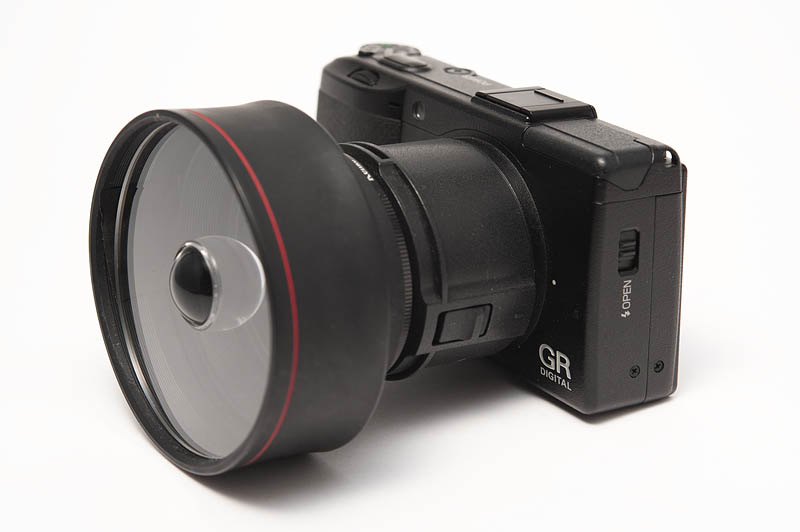 <b>宙玉レンズを装着したリコーGR DIGITAL III。アダプター（GH-2）にステップアップリング（43mm→49mm）を付け、49mmのラバーフード（HOYAマルチレンズフード）の内側に宙玉レンズを装着した</b>