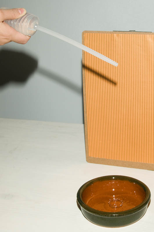 <b>こんな感じで柄のある紙や布地をバックにすると、それが水滴の中に映り込む。受け皿の方にはウォータークラウンができている</b>