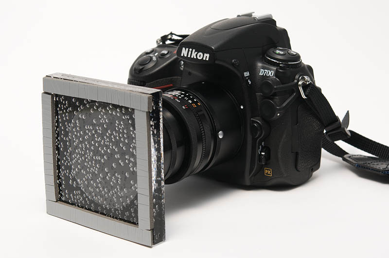 <b>アクリル板をレンズに取り付けたところ。スプレーで水滴を吹きつけながら撮影をするよりは、ずっと楽。ただしホコリがついていたりすると映りこんでしまうので注意が必要</b>