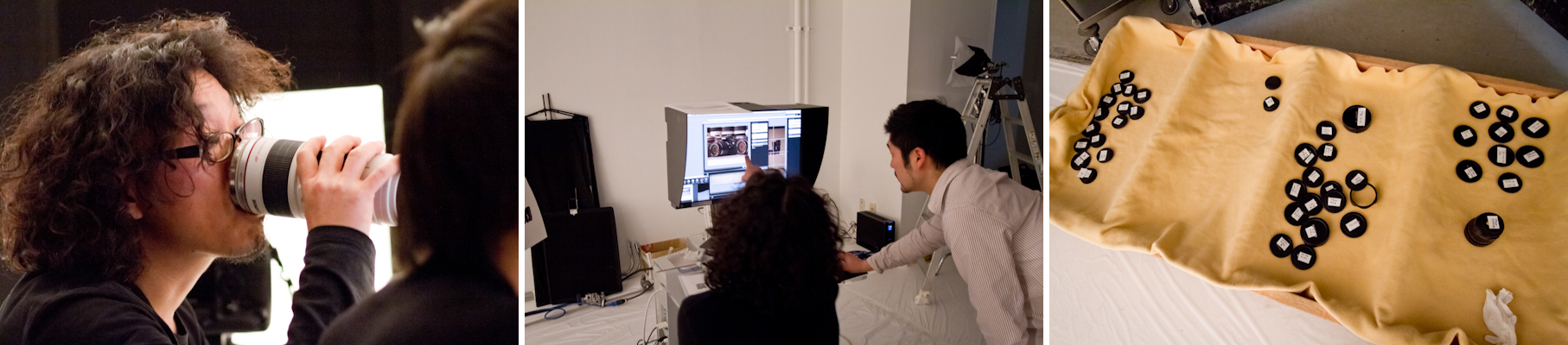 <b>望月氏が口元に持っているのは、ホンモノのレンズじゃなくEF70-300のレプリカ・マグカップ。こんな小さな芸は、緊張が続く撮影現場では大事な気遣いである。本人が遊んでるだけの場合もあるんだけど（笑）。レンズを安全に並べられるように敷かれたセーム皮の化け物みたいな場所に置かれてる、カメラボディやレンズの前後キャップの山がすごい数だ。</b>