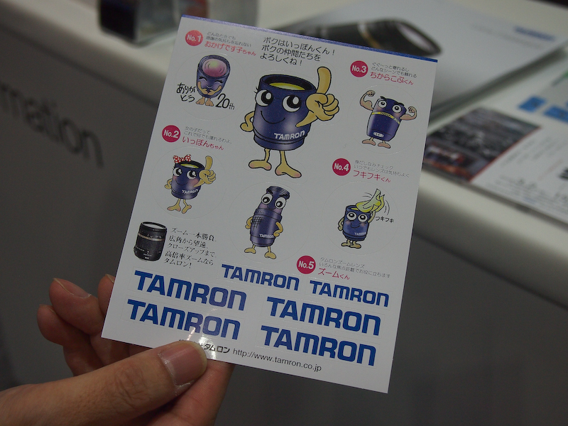 <b>ブース内にあるタムロンのキャラクターを手持ちのカメラで撮影してすべて揃えると、先着200名にシールがもらえるキャンペーンを行なっている</b>