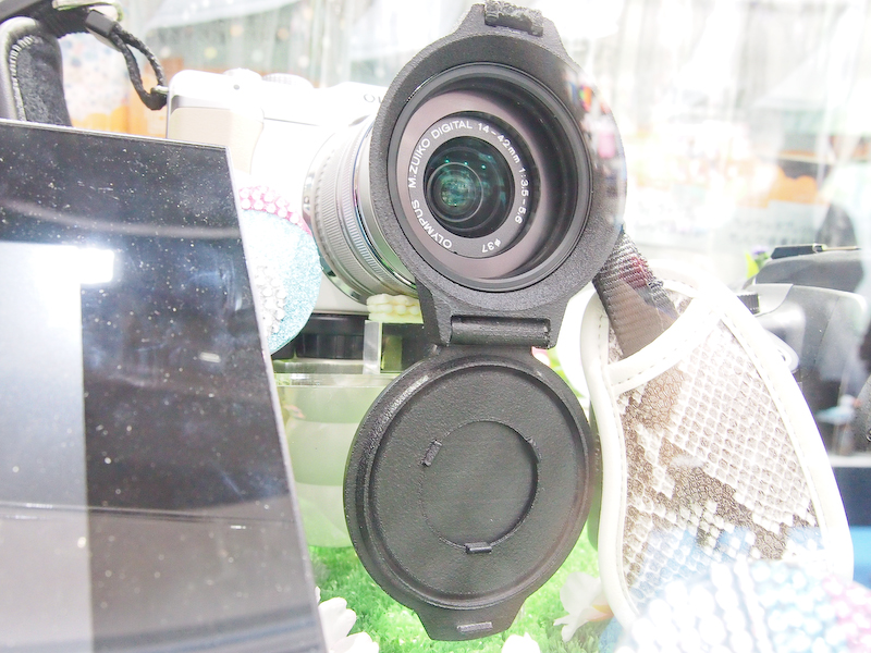 <b>開閉が簡単にできるというレンズキャップ。参考出品で発売時期と価格は未定</b>