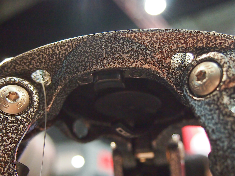 <b>さらに、本体下部にリリース用のロック解除ボタンを装備。ディスクの溝にかみ合っており、レバーを緩めただけでは外れないようにした</b>