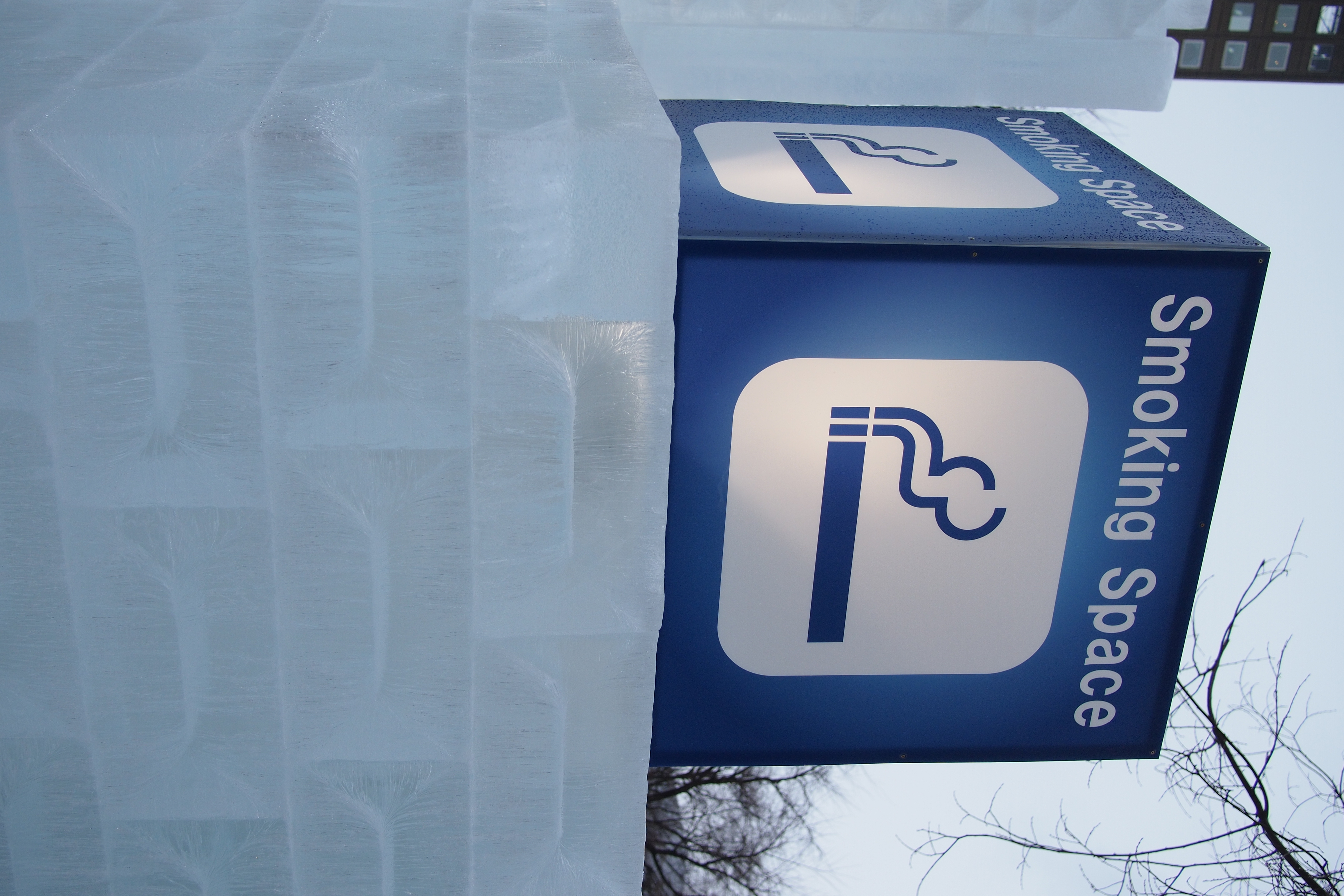 <b>喫煙所は氷で囲われてる。空気清浄機付きのプレハブのもあったけど。E-P3 / LUMIX G 20mm F1.7 / 4,032×2,688 / F2.8 / 1/1600秒 / 0.3EV / WB:晴天 / 20mm</b>