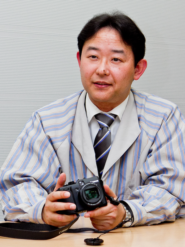 <b>レンズ光学系とファインダーを担当した猿渡浩氏。「特にレンズは製造組立や品質管理の技術がとても大切になってきます。PowerShot G1 Xを世に出すことができたのは、キヤノンのそうした歴史的なDNAとでも言うべきものが非常にプラスに働いて、あらゆるバックアップが有り良いものができたと考えています。カメラのトータルの能力を感じて欲しいと思います」</b>