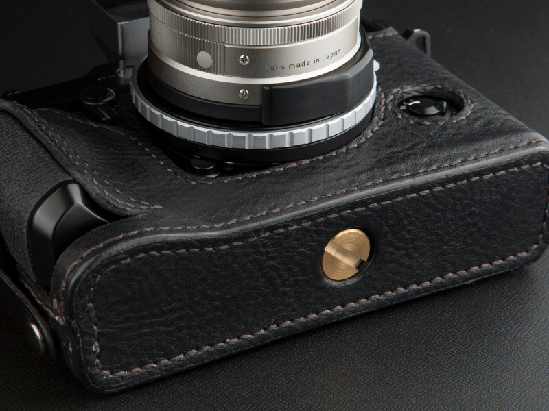 <b>真鍮製のネジで三脚穴に固定する。ネジが飛び出さない設計なので、机上に置いた際、カメラが立つ</b>