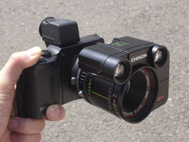 <b>丸い目玉のロボットの顔みたいなメカが合体した、リコーGXR。実はこれ、1982年に発売されたチノン「AF 50mm F1.7」で、レンズ単体で作動するAFレンズだ。今回はこれを“AFレンズユニット”として、MFユニットの「GXR MOUNT A12」に装着し、黎明期のAF機能を味わってみる。また、マウント変換リングにも工夫を施した。</b>