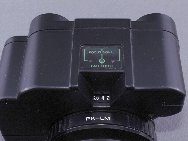 <b>レンズ後部上方から見たところ。オレンジに光るフォーカスシグナルと、絞り値を示す小窓を装備している。ただしカメラのファインダーを覗いてると、フォーカスシグナルは見えないので意味がない（笑）。</b>