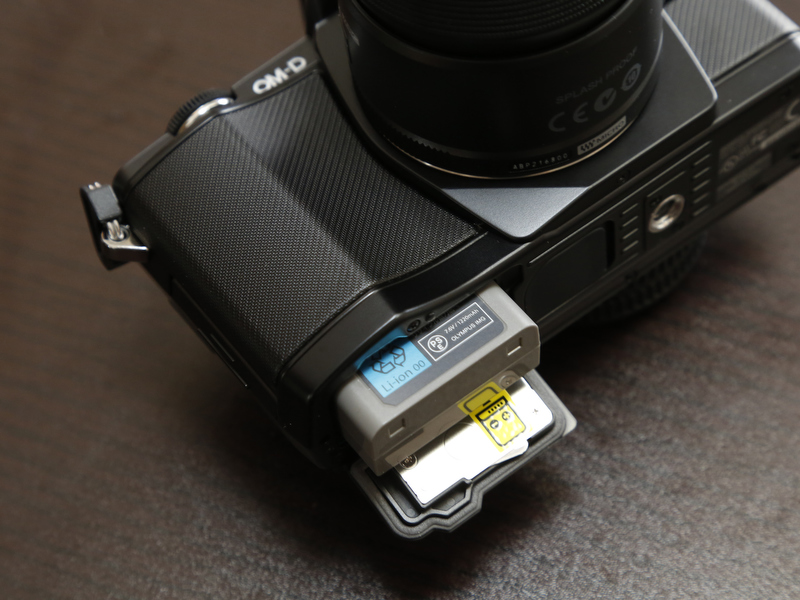 <b>BLM-5をE-M5の電池室に入れる。充電池はラベル面をカメラ前面側にして入れる。ちなみに表裏が逆では充電池を差し込むことができない。PENでは慌てて電池交換しようとするとよく表裏を間違えてしまっていたので改良と言ってよいだろう。</b>