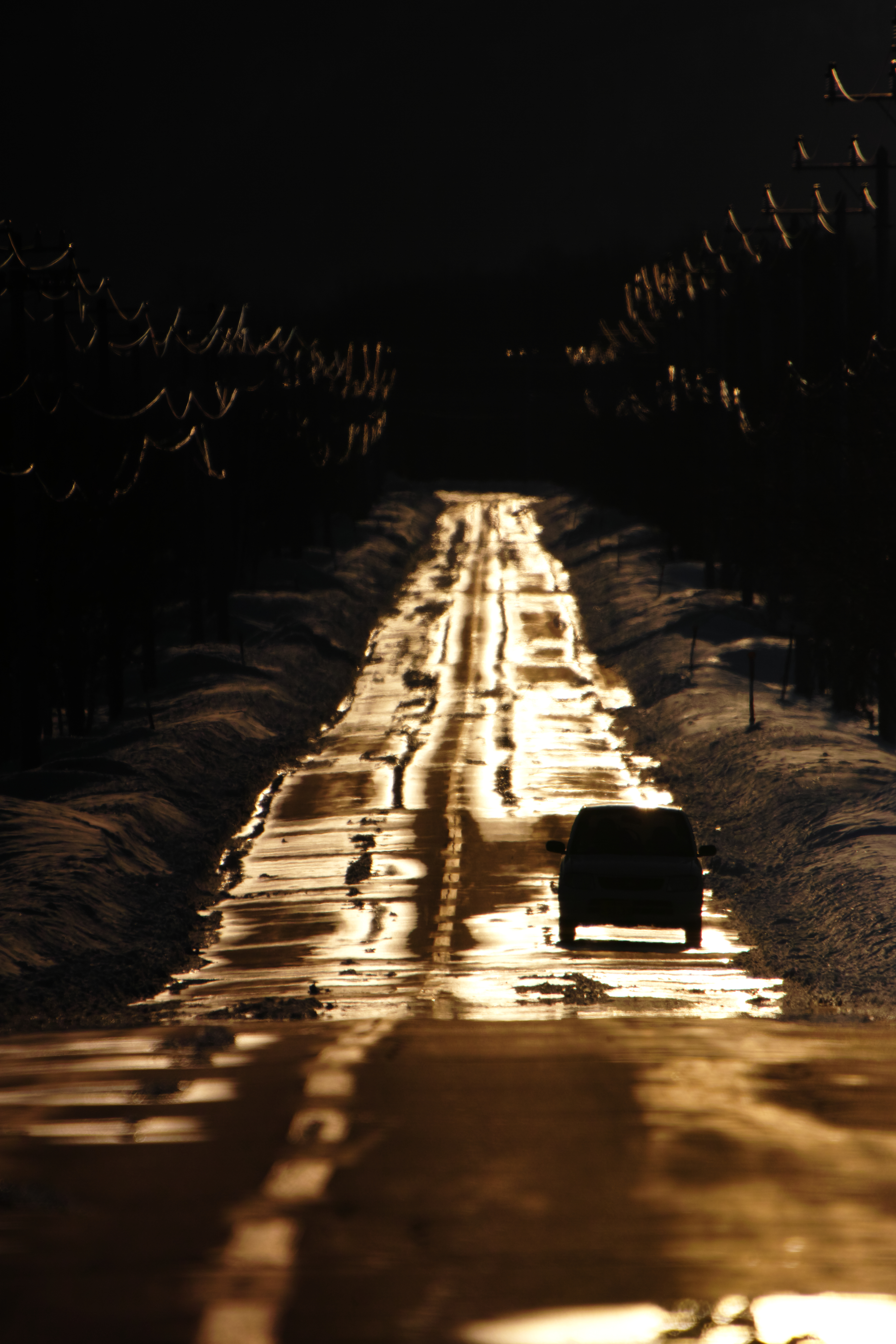 <b>平野の町から山に繋がる一本の道。除雪された道路に沿道から流れ出た雪解け水が黄金色の夕陽に輝く。しかし数キロ先からはまだ冬期通行止めのまま。まだしばらくは人を阻み続ける。SD1 Merrill / 50-500mm F4.5-6.3 DG OS HSM / 約6.4MB / 3,136×4,704 / 1/8000秒 / F6.3 / 0.0EV / ISO200 / 500mm</b>