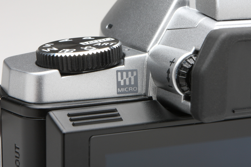 <b>マイクロフォーサーズのロゴはカメラ前面にあるPENシリーズとは異なり、背面の比較的目立たないところへ。EVF用の視度調整ダイヤルが右に見える。</b>