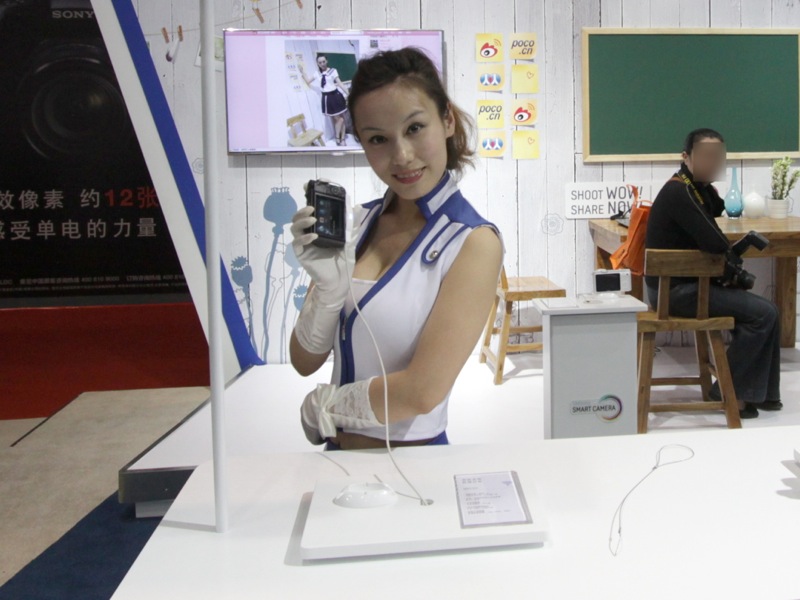 <b>コンパニオンが手にしているのはNX210。撮影体験ができた。</b>