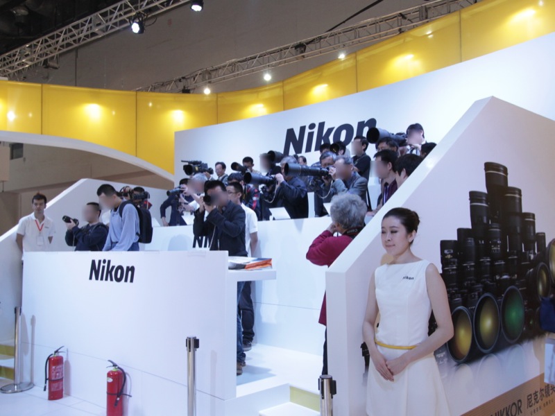 <b>ニコンブースのレンズ体験コーナー。順番待ちの列ができていた。</b>