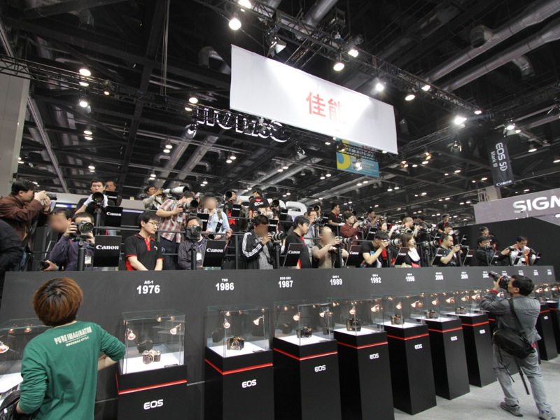 <b>レンズ体験コーナー。その下には歴代のEOSカメラを展示する。</b>