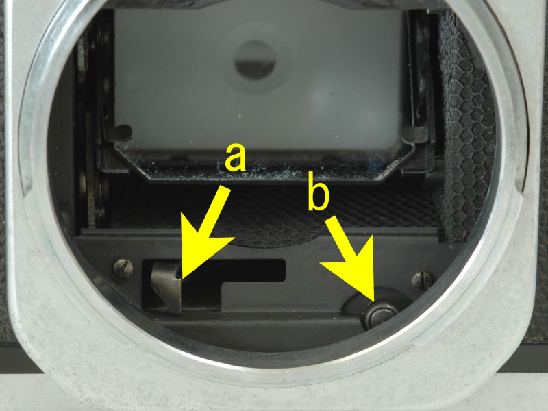 <b>Rマウントのボディ側、aのレバーで自動絞りの駆動スプリングをフィルム巻き上げに連動してチャージし、bのピンの上下運動で自動絞りを実行する</b>