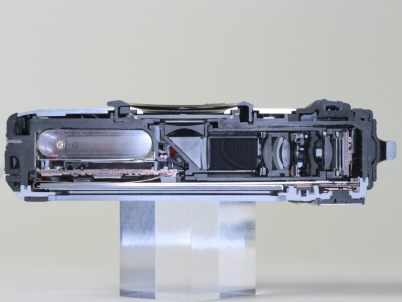 <b>TG-1のカットモデル。屈曲光学系ながら、配置の工夫でレンズ開口部をボディ中央に持ってきている（編集部撮影）</b>