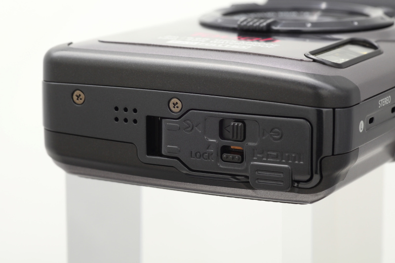 <b>端子部の蓋も厳重に二重ロック。この写真ではスライドがまだロックされていない状態。オレンジ色の注意喚起マークが見える</b>