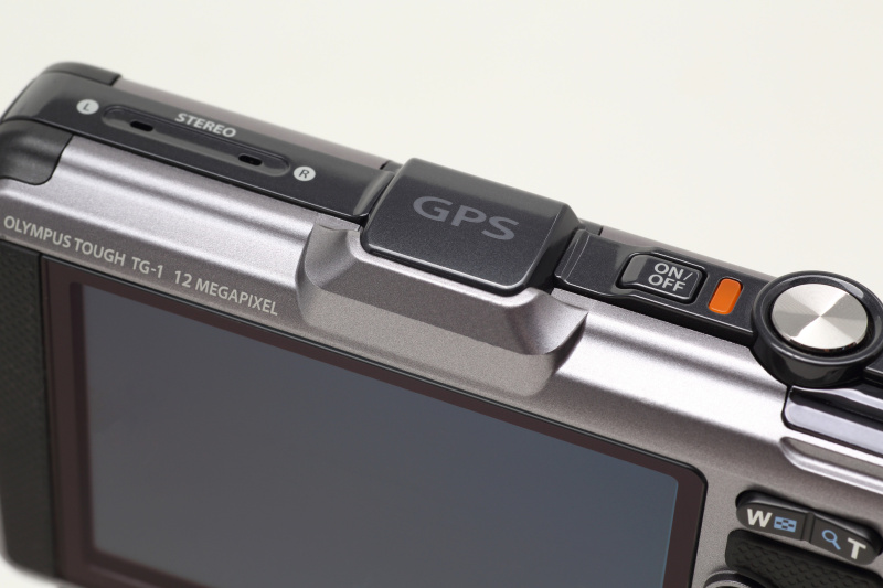 <b>右からシャッターボタン、電源ON/OFFボタン。カメラ中心にあるのがGPSアンテナ部。左にはステレオマイク。マイク穴には透湿性防水フィルムを使用することで防水性を確保している</b>