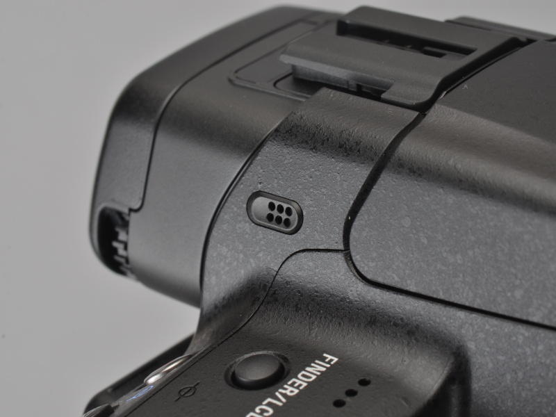 <b>EVFの接眼部分は後方へ大きく出っ張っているため、液晶モニターへ鼻が接触しにくい。接眼部前方には左右にステレオマイクが配されている</b>