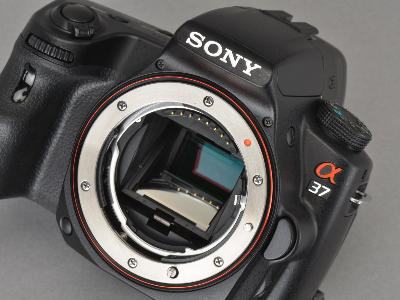 <b>レンズを外すと一眼レフと同じように大きなミラーが見える。レンズから入って来たほとんどの光はこのトランスルーセントミラーを透過して撮像素子へ向かうが、ごく一部の光は反射されて位相差AFセンサーへ届く</b>