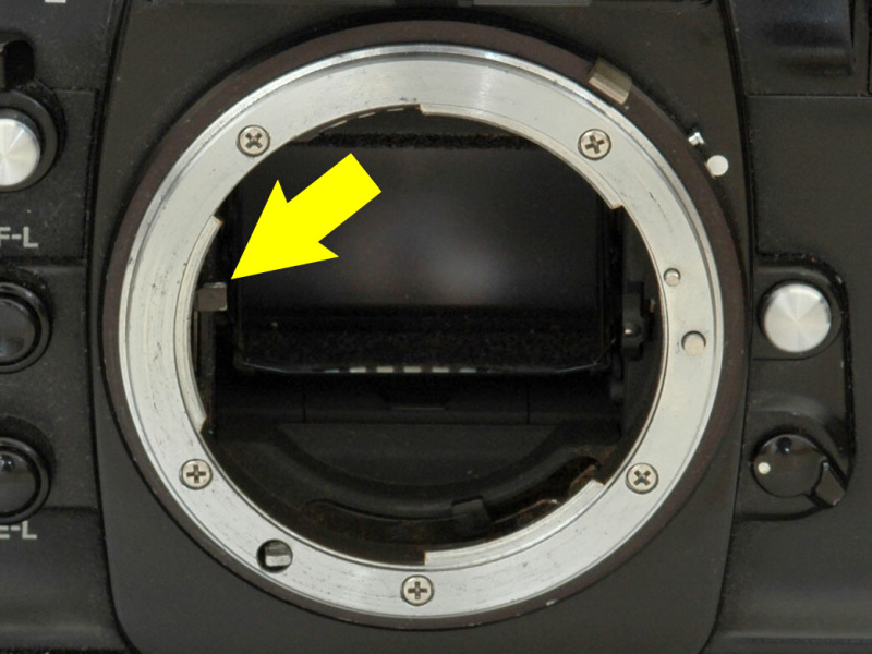 <b>ボディ側の自動絞り駆動レバー（矢印）。クイックリターンミラーの動きに連動してこのレバーが上下し、レンズ側の自動絞り連動レバーを動かす</b>