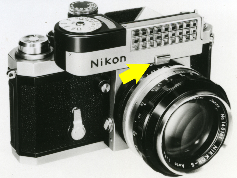 <b>外付けの露出計「ニコンメーター」を装着したニコンF。矢印の部分で「カニの爪」が設定絞り値を露出計に伝えている</b>