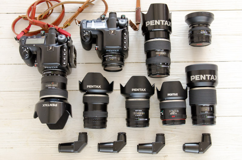 <b>今回のスクールガール撮影はもちろん、現在の一番メインになっているペンタックスの645Dセット。レンズ類は銀塩645時代からのものもたくさん揃っている。多用するので失くした時のためにアングルファインダーはたくさん持っている（笑）。右は新しく導入されたニコンD800のセット。</b>