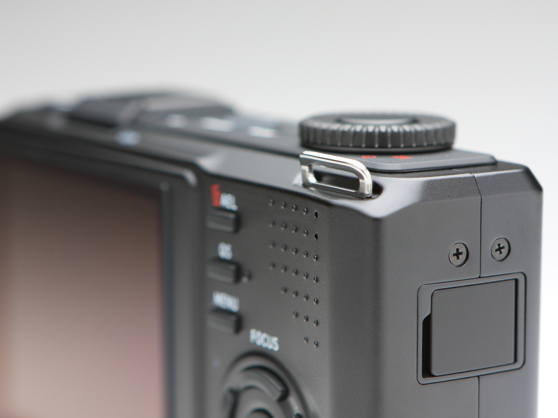 <b>シャッターボタン側のストラップ取り付け金具はイレギュラーな位置に。シャッターボタンを押す右手人指し指にストラップが干渉することがない。</b>