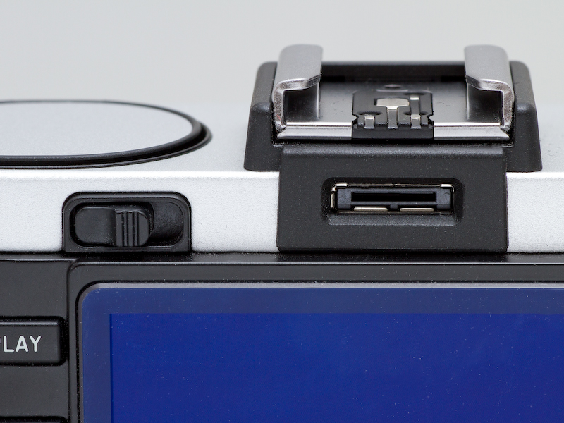 <b>背面にはEVF用の端子を装備。また左側には内蔵ストロボ用のポップアップレバーがある。</b>