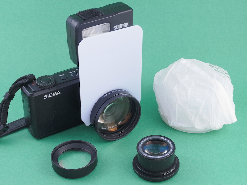 <b>「SIGMA DP2 Merrill」の潜在能力を引き出すために考案したマクロシステム。純正のクローズアップレンズに、社外品のクローズアップレンズを加えて、各種倍率に対応している。いずれの組み合わせもマスターレンズとの相性が良く、新型イメージセンサーFoveon X3 Merrillならではの高画質が堪能できる。外付けストロボとディフューザーも用意したが、全体としてコンパクトなマクロシステムとしてまとまった。</b>