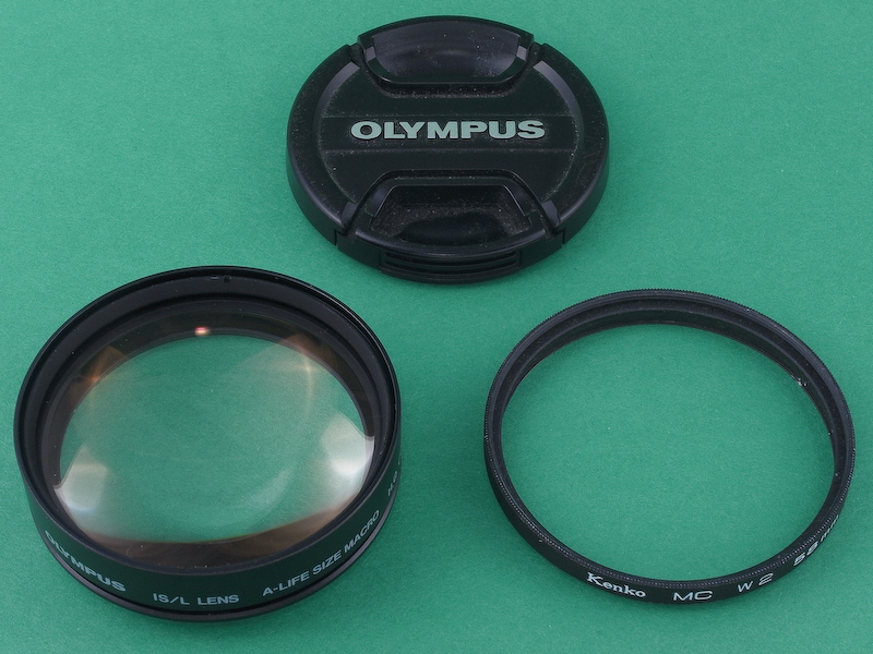 <b>このクローズアップレンズの欠点は、先端にフィルターネジが切られていないことだ。これではレンズキャップが装着できず、非常に不便。そこでガラスを抜いたジャンク品フィルター58mm径（右）を用意し、これを先端に取り付けることにした。</b>