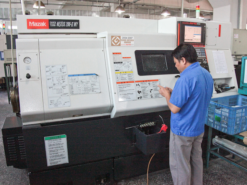 <b>劉氏自慢のCNC（コンピューター数値制御）旋盤は、工作機械大手のヤマザキマザック製。最大12本の工具による加工に対応。機械自体のわずかな熱変形も自動的に補正する機能を備えており、工作物のばらつきを低減できるという。右は切削を終えた自由雲台のベース部品</b>