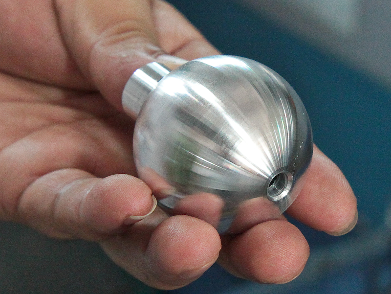 <b>先ほどプレスの工程を見せてもらった自由雲台のボール部品（左）もこれらの旋盤で仕上げる</b>