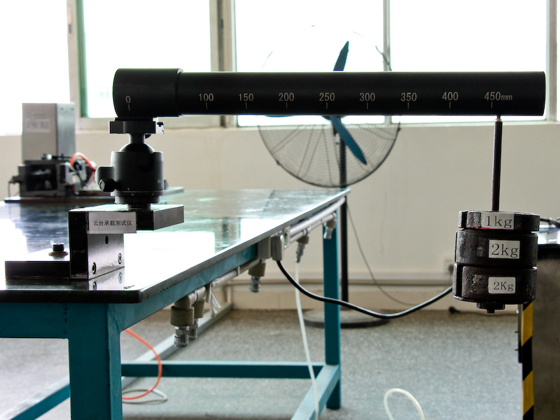 <b>雲台の固定力などを検査する装置。耐荷重相当の重りを雲台から45cm離した位置に吊して荷重をかける。この状態で24時間放置し、変化が無ければ合格だ</b>