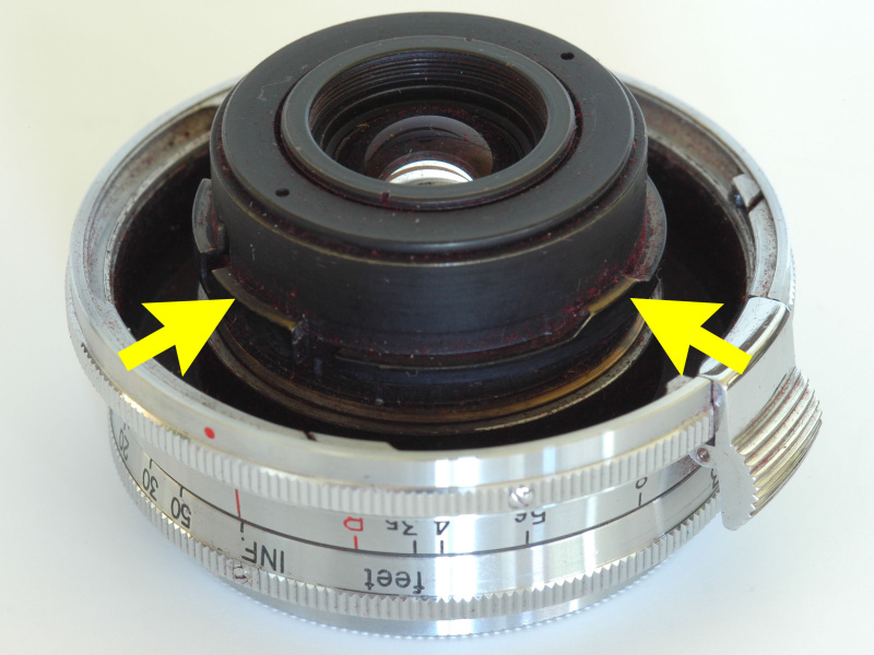 <b>レンジファインダー・コンタックスの標準レンズ以外の交換レンズは外バヨネットに装着されるが、その際フォーカシングリングと一緒に回転するリングに設けられた爪（矢印）が内バヨネットの爪の間に入り込んで回転を伝える。</b>