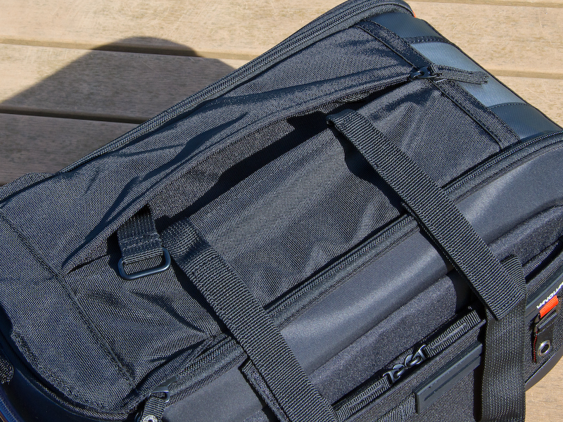 <b>バッグの上面に三脚を固定。固定用ベルトはバッグの蓋上面にあるポケットのなかに用意されている。</b>