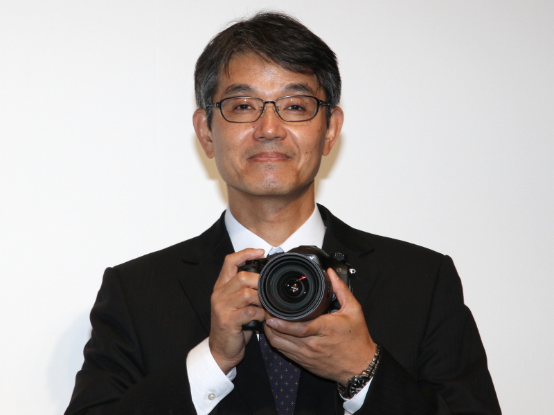 <b>α99を手にする石塚氏</b>