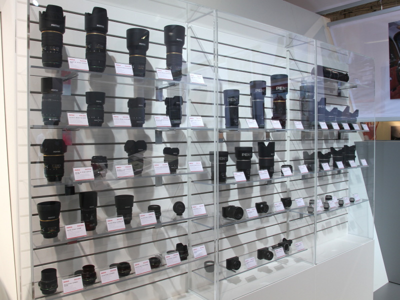 <b>ブース内のレンズラインナップ展示。リコーGXRのユニットも一緒に展示していた</b>