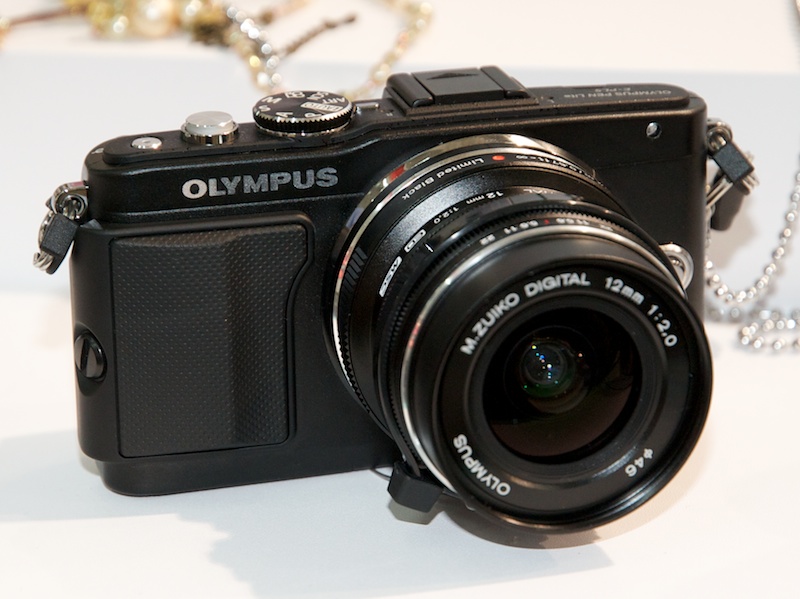 <b>OLYMPUS PEN Lite E-PL5。前モデルからE-PL3から着脱式のグリップが追加され、上位機種E-P3に近い、幾分男性的なフォルムになった。バリアングル液晶モニターは健在。レンズは同時発表のM.ZUIKO DIGITAL ED 12mm F2リミテッドブラック</b>