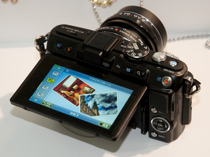 <b>OLYMPUS PEN Lite E-PL5。前モデルからE-PL3から着脱式のグリップが追加され、上位機種E-P3に近い、幾分男性的なフォルムになった。バリアングル液晶モニターは健在。レンズは同時発表のM.ZUIKO DIGITAL ED 12mm F2リミテッドブラック</b>