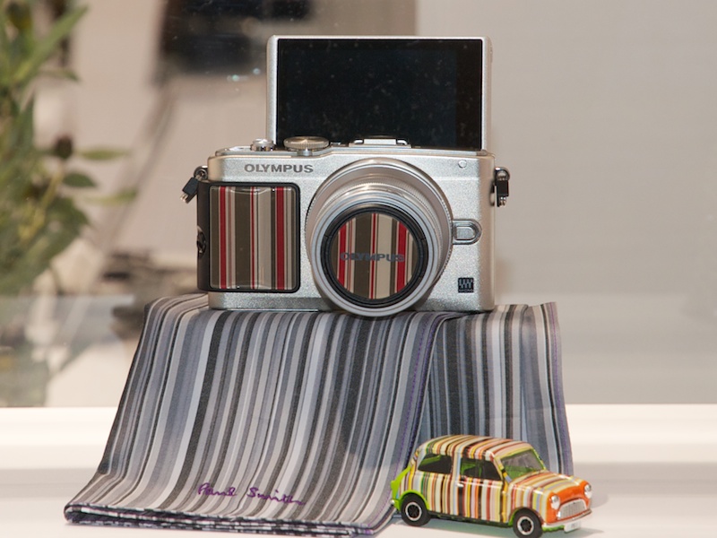 <b>別売のプレミアムカメラグリップ「MCG-3PR」とプレミアムレンズキャップ「LC-37PR」の組み合わせ例。3色あるうちのこれはストライプ柄</b>